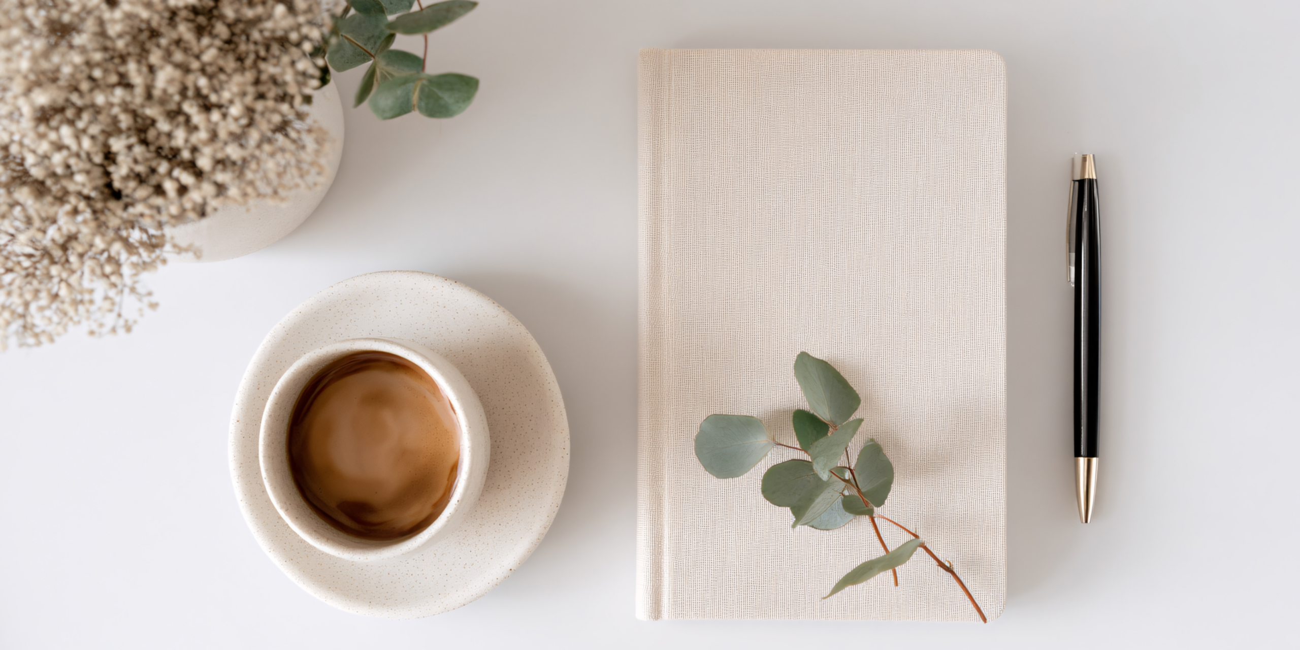 Tasse de café, carnet et feuilles posés sur une table, ambiance calme et minimaliste